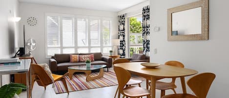 Un salon moderne comprenant un canapé, une table basse, une table à manger et des chaises.