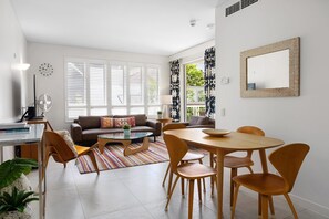 Una sala de estar moderna con sofá, mesa de centro, mesa de comedor y sillas.