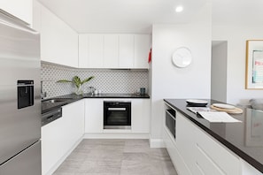 Enjoy cooking in this well-equipped kitchen with a dishwasher, stainless steel refrigerator, and ample countertop space.