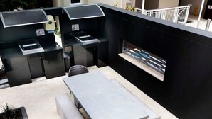 Eine Außenpatio mit einer integrierten Grillstation, einem Tisch und einem Stuhl.