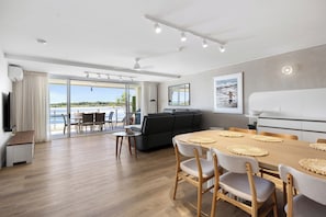 Relax in this stylish living space with a sofa set, dining table, and TV.