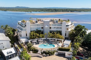 A hotel with a pool, beachfront view, and multiple balconies. - Las Rias, Riverside Luxury Bliss (Noosa Heads)