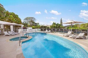 A swimming pool with lounge chairs and umbrellas, surrounded by palm trees and a clear sky. - Las Rias, Riverside Luxury Bliss (Noosa Heads)