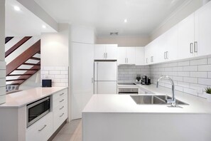 Enjoy cooking in this well-equipped kitchen with an oven, microwave, and stainless steel sink.