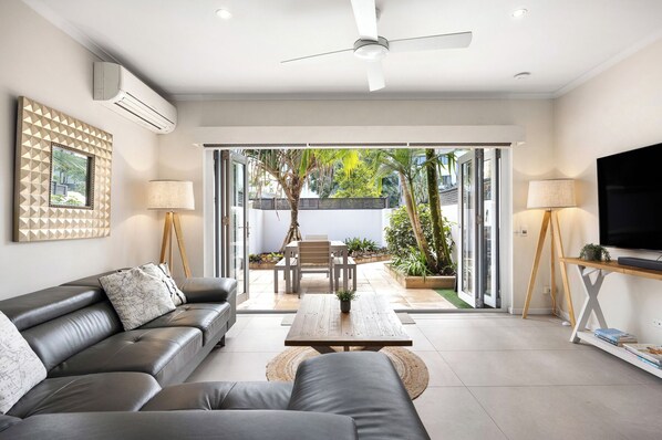 Relax in this stylish living room with a sofa, coffee table, and TV, offering a view of the outdoors.