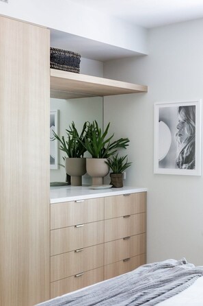 A bedroom with a bed, a dresser with drawers, a mirror, and a framed picture on the wall.