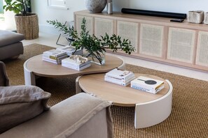 Ein modernes Wohnzimmer mit einer Couch, zwei Couchtischen und einem Bücherregal.