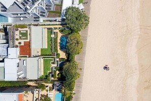 Ein Resort mit Pool, Zugang zum Strand und einem großen Gebäude mit Schwimmbad.