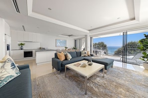 Relax in this spacious living area with a sofa, coffee table, and ocean views from the balcony.