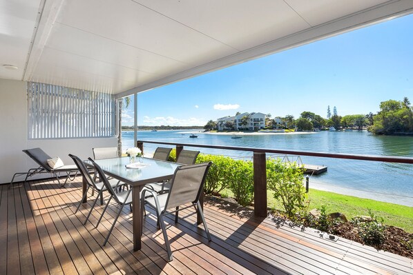 Relax on the deck with a view of the serene lake and distant shoreline.