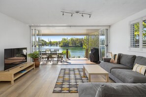 Relax in this serene space with a flat-screen TV, comfortable sofa, and dining area overlooking the lake.