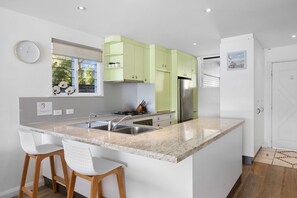 Enjoy cooking in this well-equipped kitchen with a central island, gas stove, and stainless steel sink.