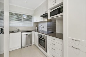 Enjoy cooking in this well-lit kitchen with appliances and a microwave.