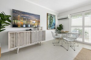 Enjoy meals in this stylish dining area with a large flat-screen TV and glass-top dining table.