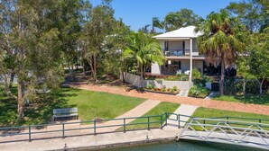 A residential property with a swimming pool, a bridge, and a well-maintained garden.