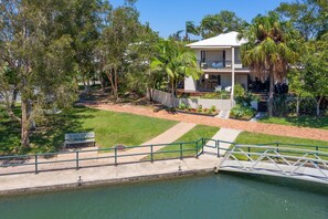A residential property with a swimming pool, a bridge, and a well-maintained garden.