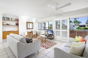 Relax in this cozy living space with a sofa, TV, and bookshelf.