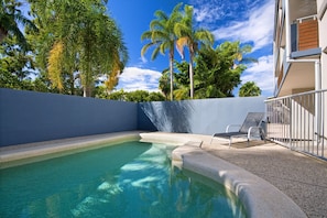 Relax by the serene pool surrounded by lush greenery and modern architecture.
