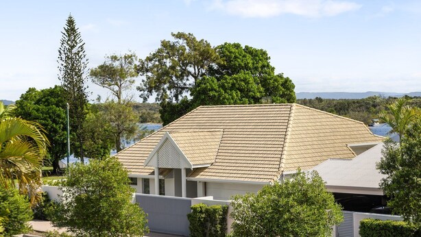 A residential building with a sloped roof, surrounded by lush greenery and a clear sky. - Soundhaven 4 - Noosa Parade Value (Noosa Heads)