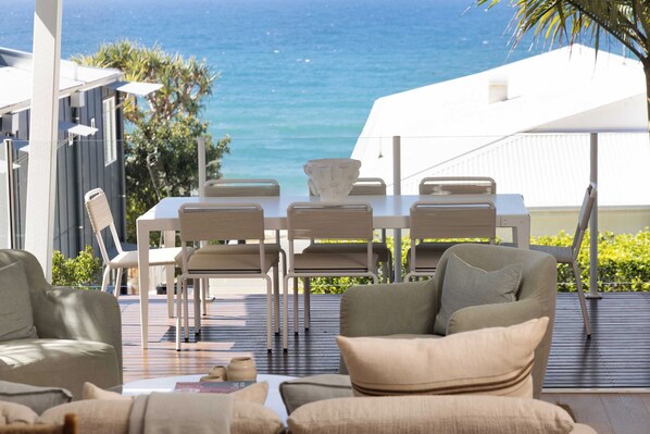 An outdoor seating area with a table and chairs, overlooking a body of water.