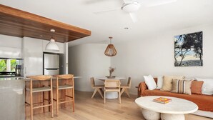 Um espaço de estar moderno com cozinha, área de refeições e zona de estar.