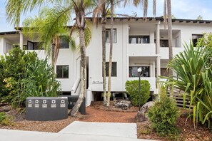 A multi-story building with a white exterior, a covered entrance, and a sign reading 'S. Tropes'.