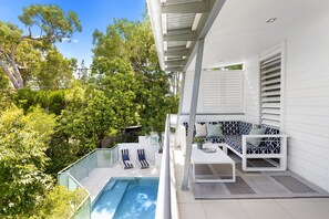 Relax in a serene outdoor space surrounded by lush greenery and a small pool.