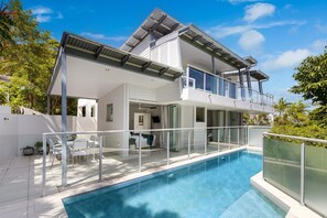 A modern two-story house with a swimming pool, large windows, and a balcony. - Stunning Duplex with Rooftop Terrace (Little Cove)