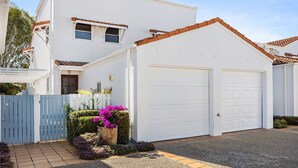 A two-story residential building with a white facade, a brown roof, and a white garage. - Villa Aqua - Riverside Retreat with Pool (Noosaville)