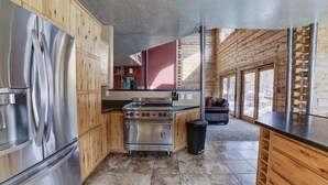 Una cocina moderna con armarios de madera, electrodomésticos de acero inoxidable y un ventanal que proporciona luz natural.