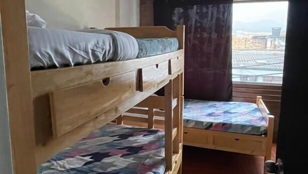 A dormitory room with two bunk beds, a window with curtains, and a tiled floor. - HOSTEL PARA VIAJEROS (Bogotá)
