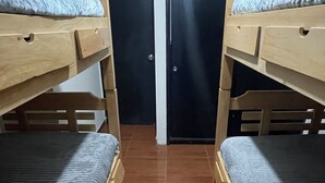 A room with two bunk beds, a door, and a tiled floor. - HOSTEL PARA VIAJEROS (Bogotá)