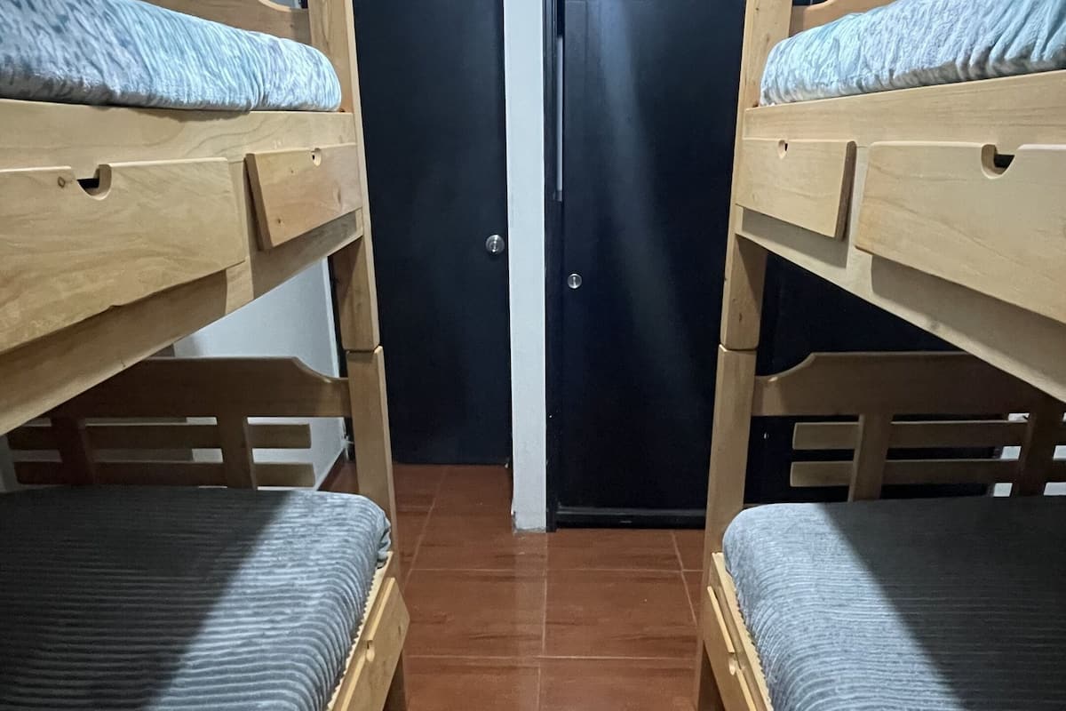 A room with two bunk beds, a door, and a tiled floor.