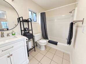 Een moderne badkamer met een wit wastafel, toilet en bad.