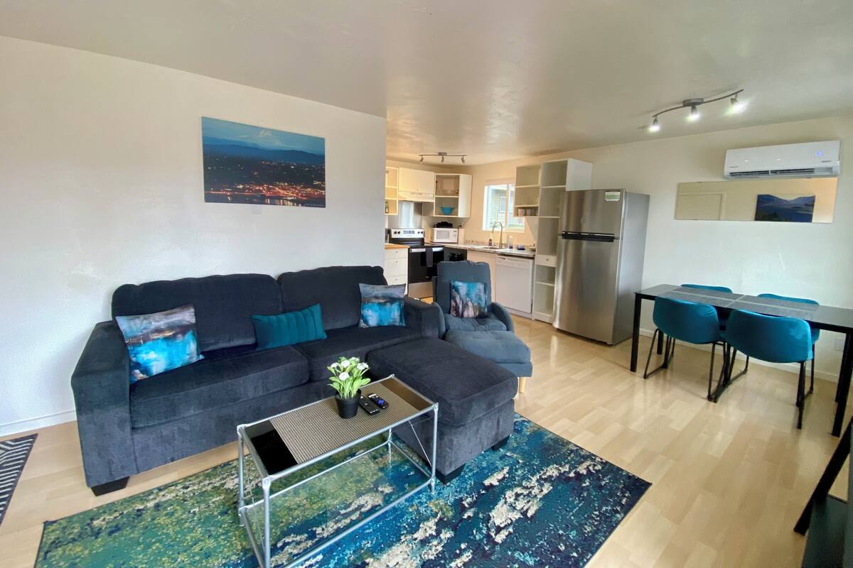 Una sala de estar moderna con un sofá, una mesa de centro y un comedor con sillas y una mesa.