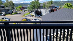 A residential area with houses, parked cars, and a clear view of mountains in the background.