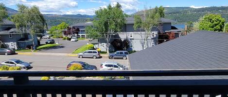 A residential area with houses, parked cars, and a clear view of mountains in the background.