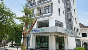 A multi-story hotel with a modern design, featuring balconies on each floor and a sign indicating it is the Romano Hotel. - Romano Hotel (Kampot)