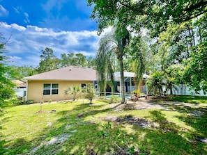 A single-story house with a fenced backyard, a swimming pool, and a covered patio area.