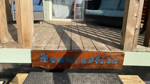 Une terrasse en bois sur laquelle est accrochée une enseigne portant le mot « Colibri ».