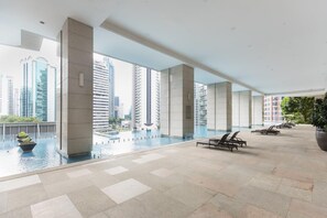 A modern indoor pool area with clear views of surrounding high-rise buildings. - Opus BT  (Kuala Lumpur)