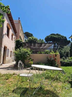 Relax in a serene outdoor setting with a shaded patio, perfect for dining or socializing amidst lush greenery.