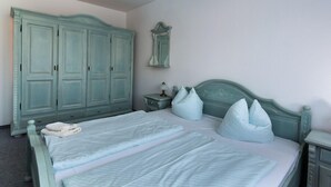 A bedroom with a bed, two nightstands, a wardrobe, and a mirror. - Spreewald-Familienherberge (Lübbenau/Spreewald)