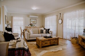 Ein Wohnzimmer mit einer Couch, einem Couchtisch und einem Essbereich mit Stühlen und einem Tisch.