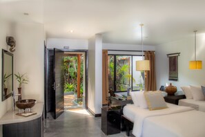 Una camera d'albergo moderna con un letto grande, una scrivania e vista su un giardino rigoglioso.