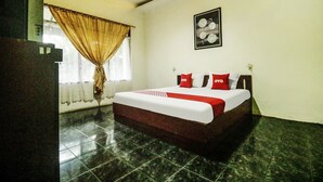 A hotel room with a bed, a window with curtains, a framed picture on the wall, and a tiled floor. - Hotel O Nyi Rindang Near Puskesmas Jekan Raya (Palangkaraya)