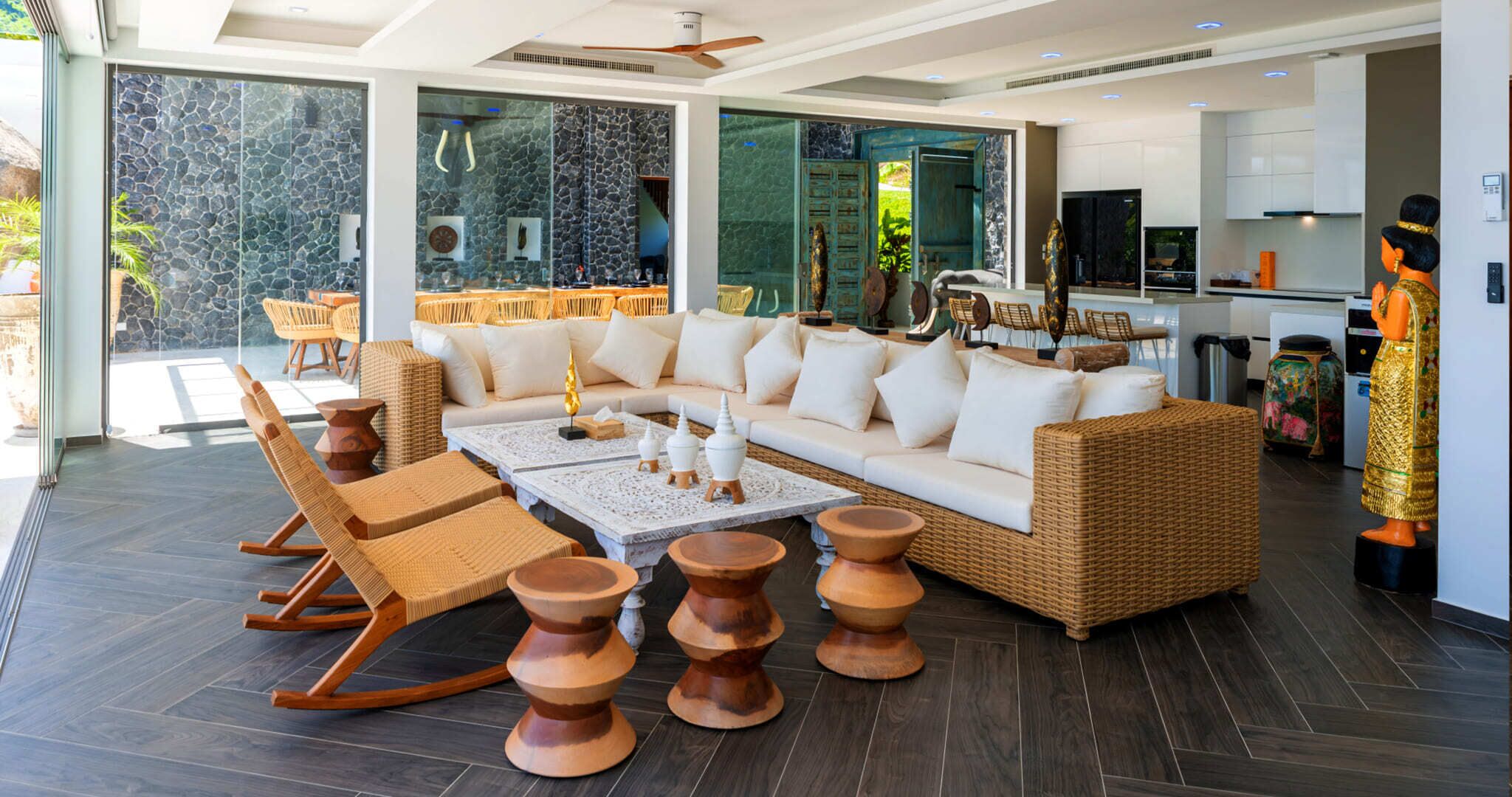 Una sala de estar moderna con un sofá grande, sillas de madera y una mesa de centro.