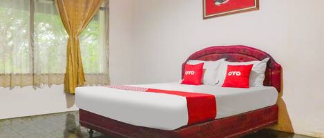 A hotel room with a bed, curtains, a painting, and a tiled floor.