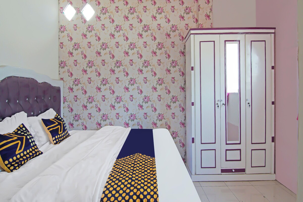 Une chambre à coucher avec un lit, une armoire et un papier peint à motifs floraux.
