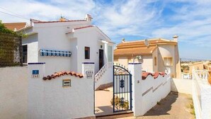 A residential building with a white facade, a red-tiled roof, and a gated entrance. - CH Villa Africa La Marquesa Golf (Ciudad Quesada) (Ciudad Quesada)